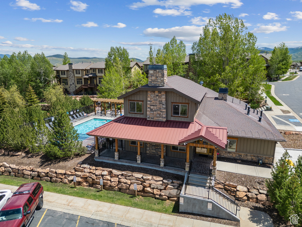 View of front of house with a chimney, board and batten siding, and stone siding