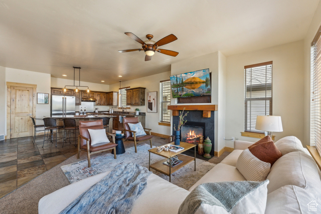 Living room with a ceiling fan, baseboards, a fireplace, and recessed lighting