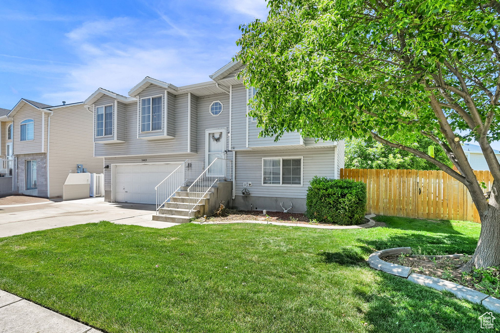 View of front of property with concrete driveway and an attached garage