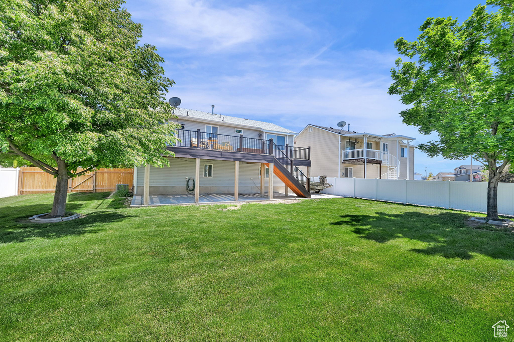 Rear view of house with stairway, a patio, and a wooden deck