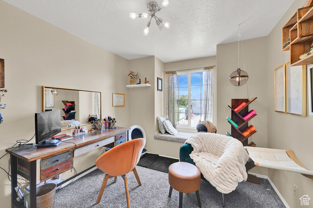 Carpeted home office with a textured ceiling, a chandelier, and baseboards
