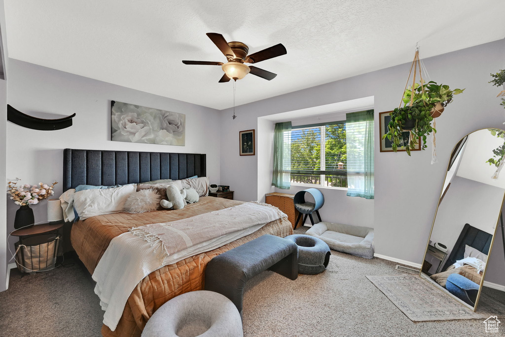 Carpeted bedroom featuring ceiling fan and baseboards