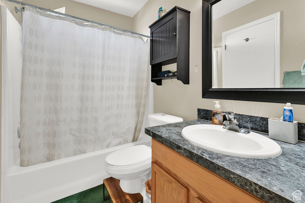 Full bath featuring vanity, toilet, and shower / bathtub combination with curtain