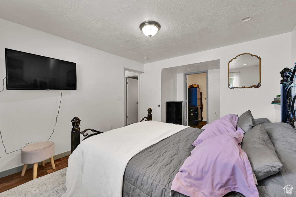 Bedroom featuring a textured ceiling, wood finished floors, and baseboards