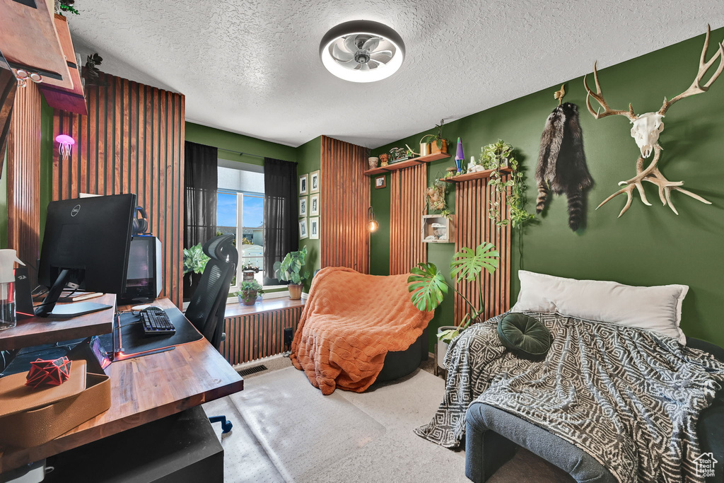 Office featuring a textured ceiling, radiator, and carpet floors
