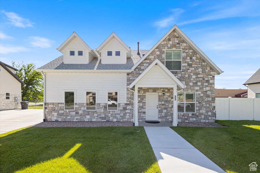 View of front facade with stone siding and roof with shingles