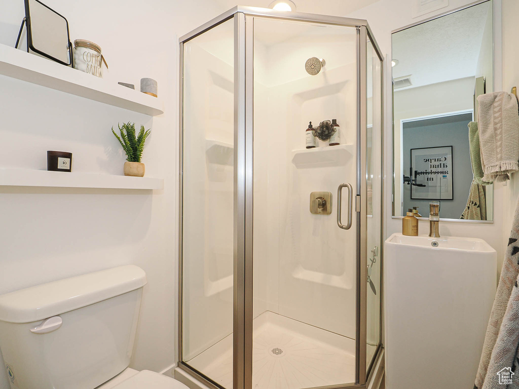 Full bath featuring toilet and a stall shower