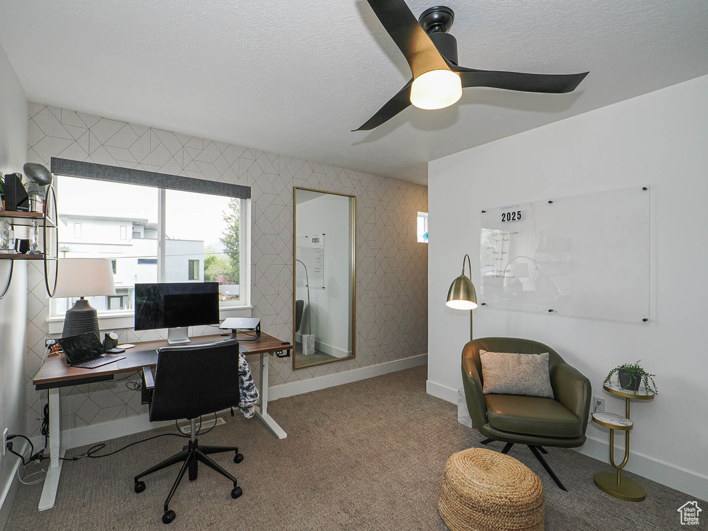 Office area with baseboards, a textured ceiling, a ceiling fan, and carpet flooring