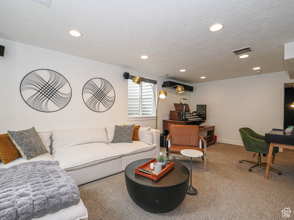 Living area featuring carpet flooring, recessed lighting, a textured ceiling, a desk, and baseboards