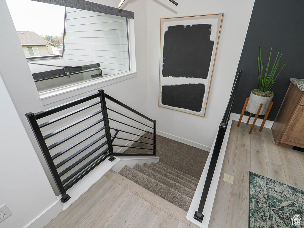 Stairway featuring wood finished floors and baseboards