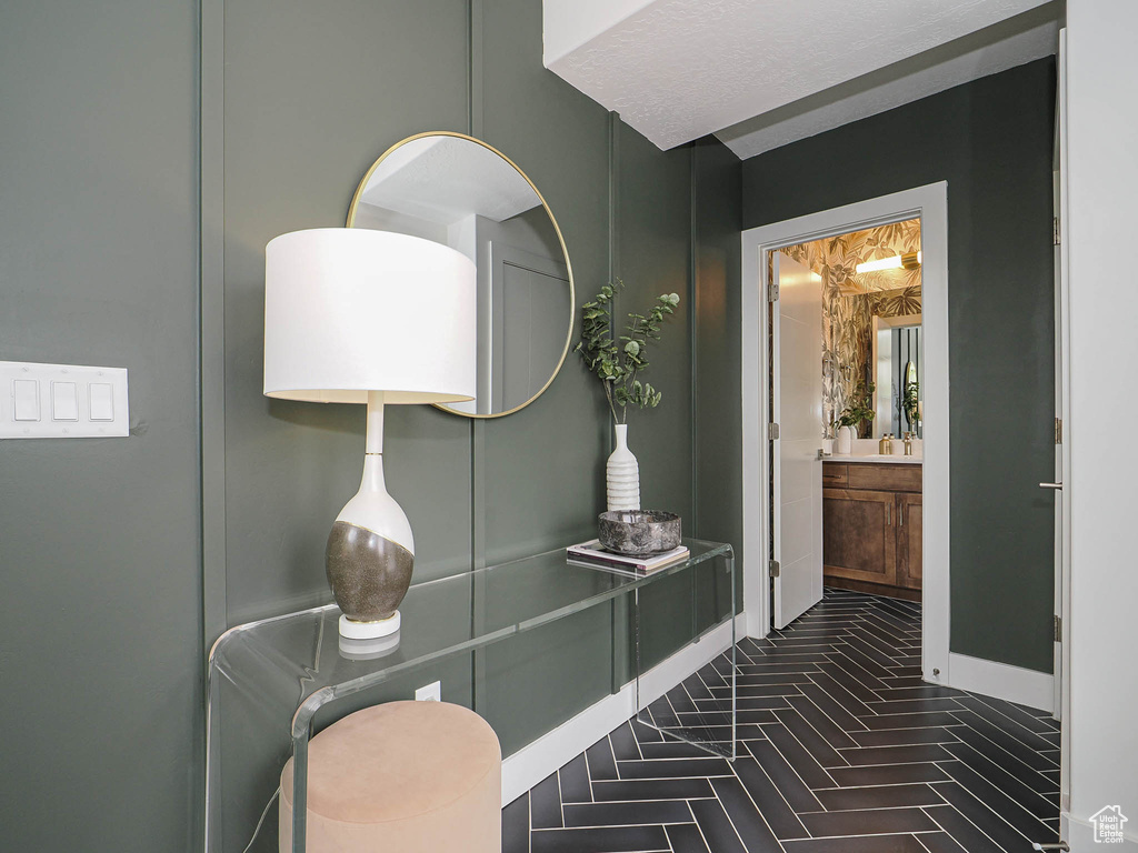 Bathroom with vanity, baseboards, and brick patterned floors