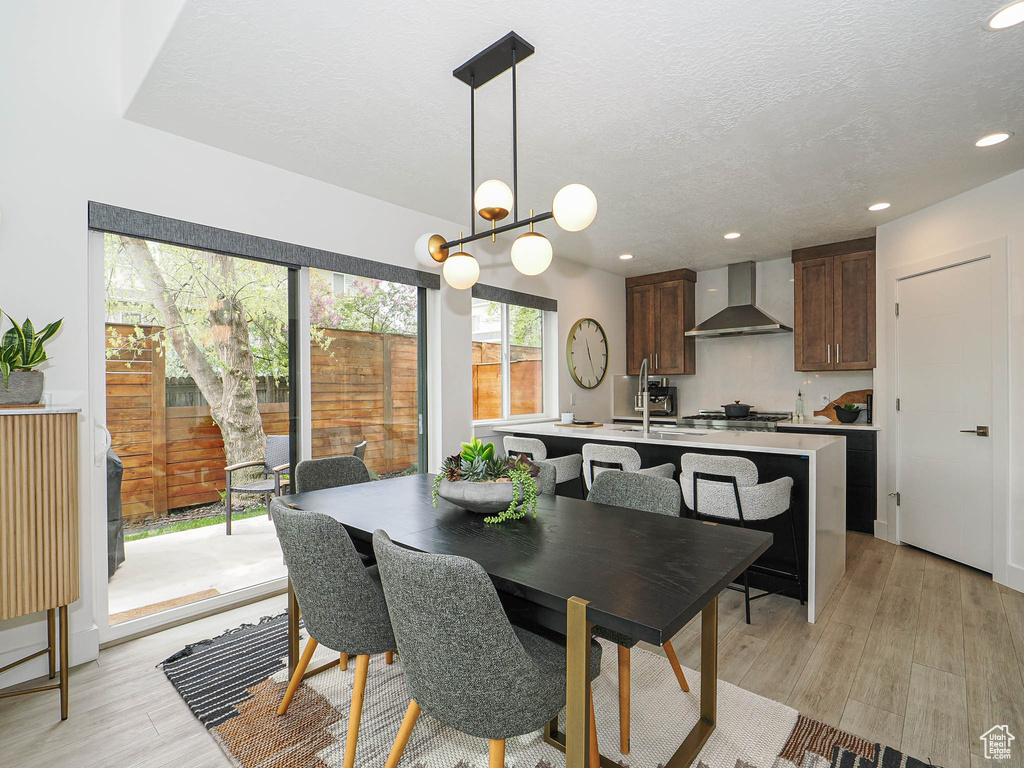 Dining room featuring a textured ceiling, light wood-style flooring, and recessed lighting