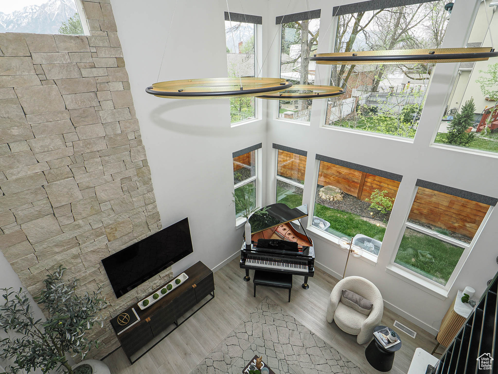Living room featuring wood finished floors, a high ceiling, and baseboards