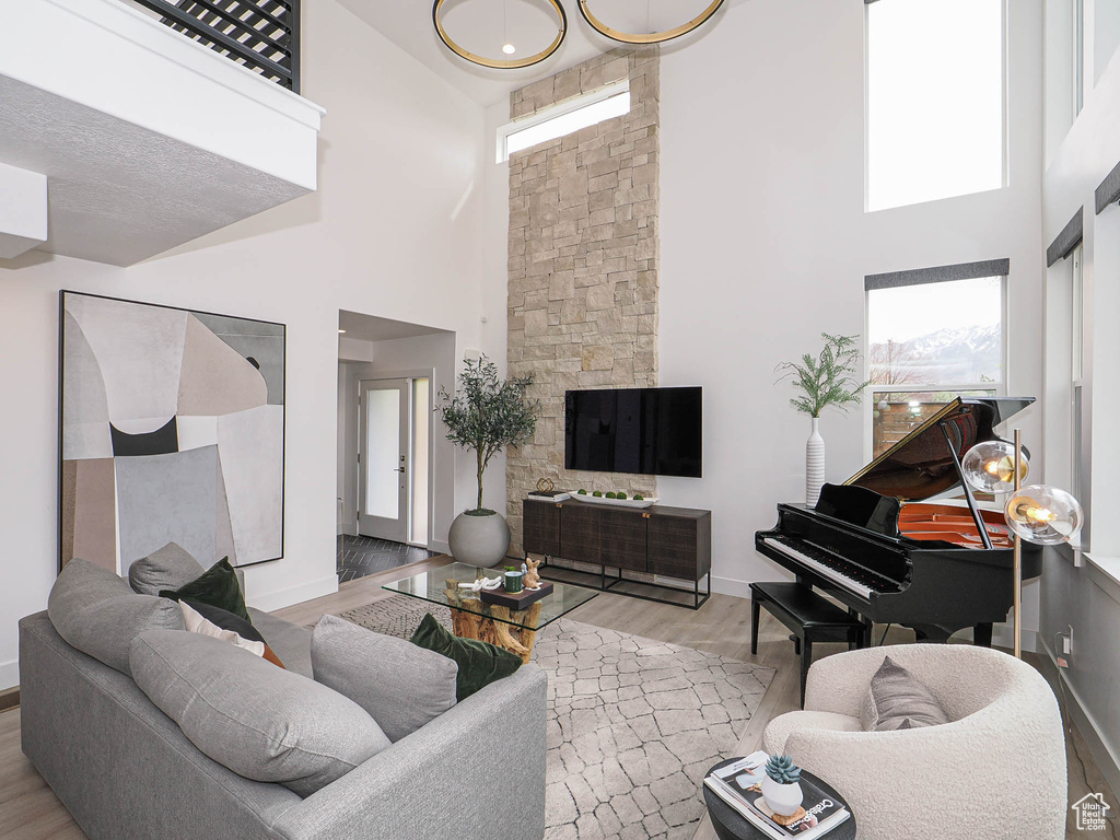 Living room featuring a high ceiling, wood finished floors, and baseboards