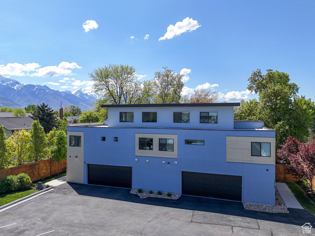 View of front of property with a garage, a mountain view, and stucco siding