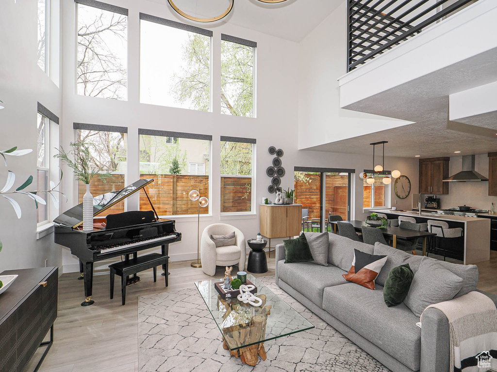 Living room featuring a towering ceiling and light wood-style flooring