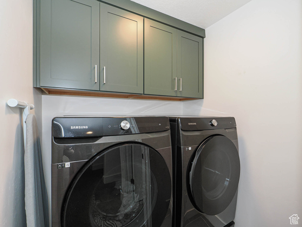Laundry area featuring washer and dryer and cabinet space