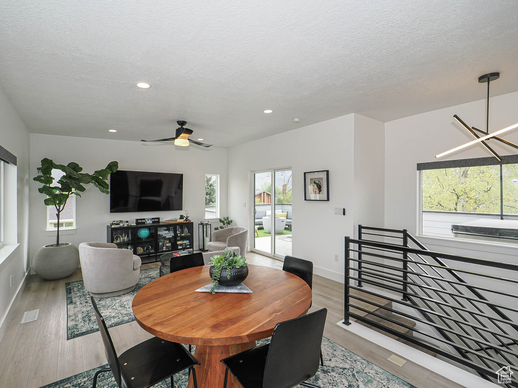 Dining area with wood finished floors, a textured ceiling, ceiling fan, recessed lighting, and baseboards