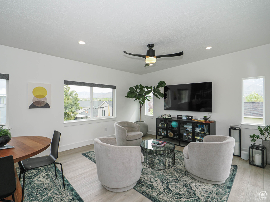 Living room with baseboards, wood finished floors, a ceiling fan, and recessed lighting