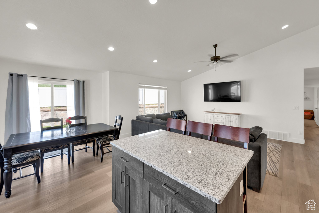 Kitchen with plenty of natural light, lofted ceiling, light wood-style floors, ceiling fan, and recessed lighting