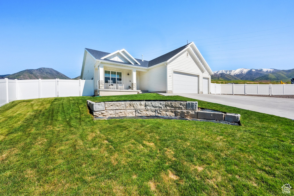 View of front facade featuring an attached garage, driveway, a mountain view, and covered porch