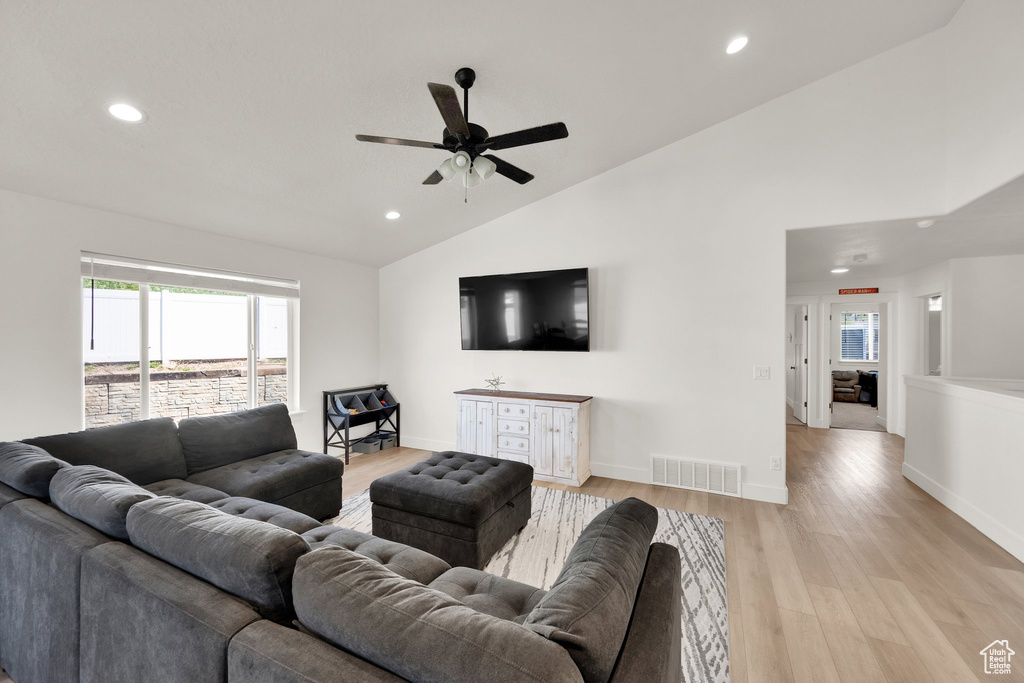 Living room featuring recessed lighting, a ceiling fan, light wood-style floors, high vaulted ceiling, and baseboards