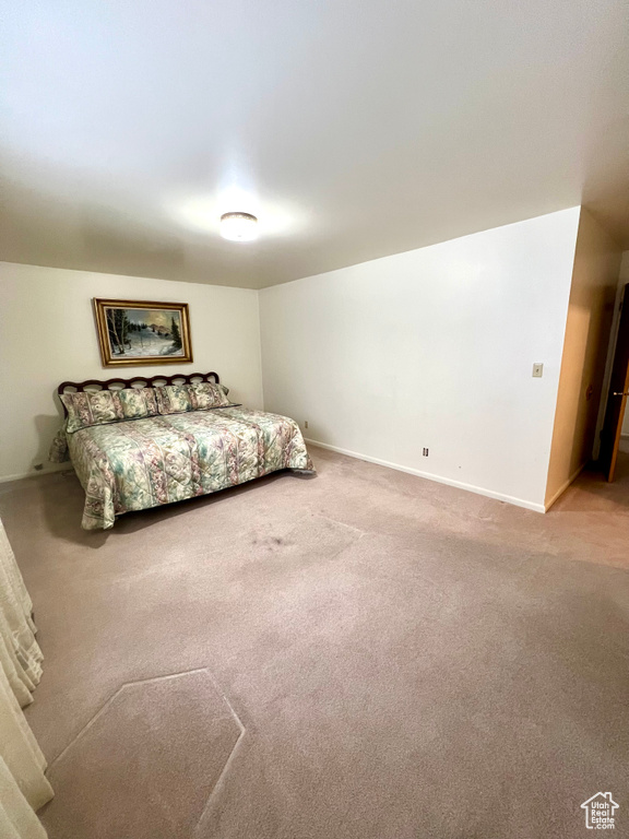 Bedroom with light colored carpet and baseboards