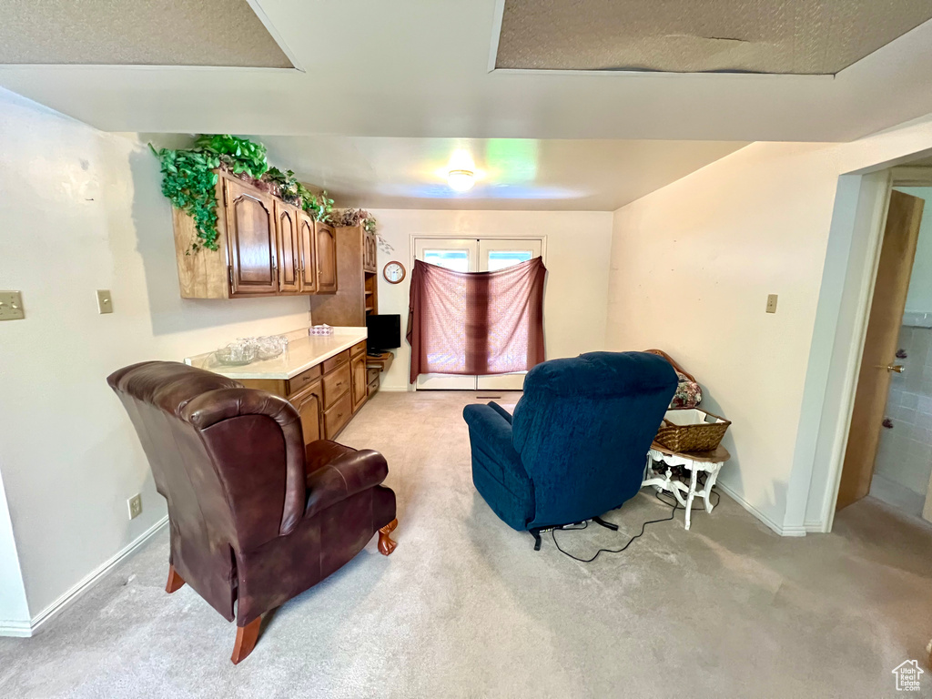 Living area with light colored carpet and baseboards