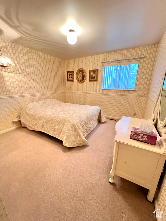 Carpeted bedroom with wallpapered walls