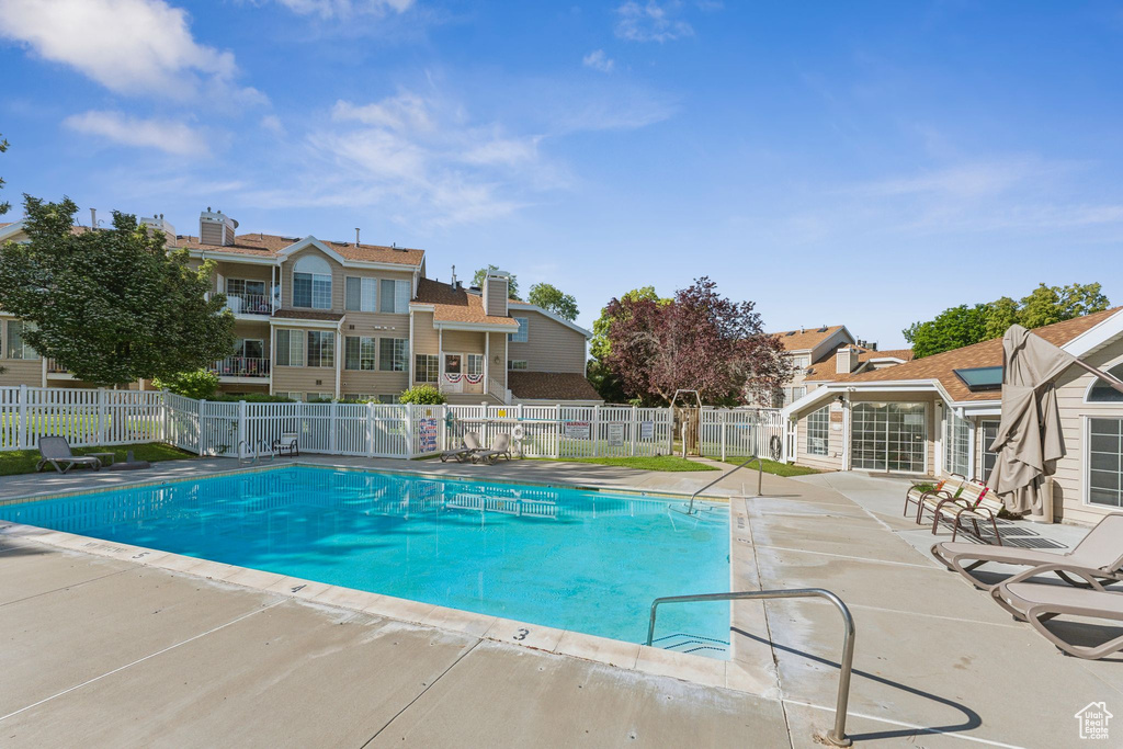 Community pool with a patio area and a residential view