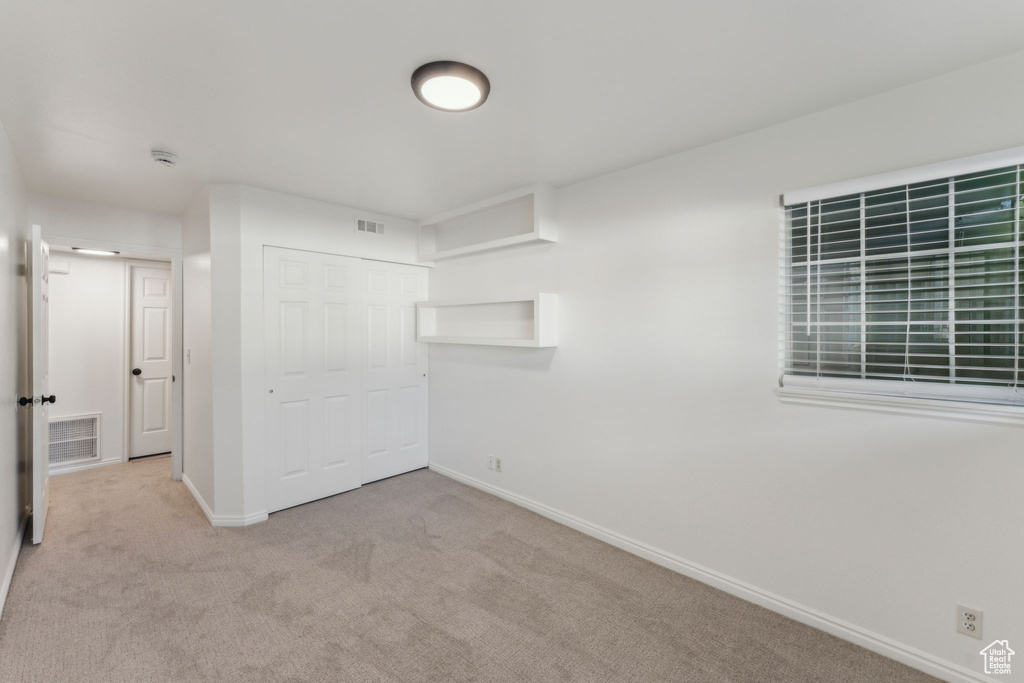 Unfurnished bedroom featuring baseboards, a closet, and carpet