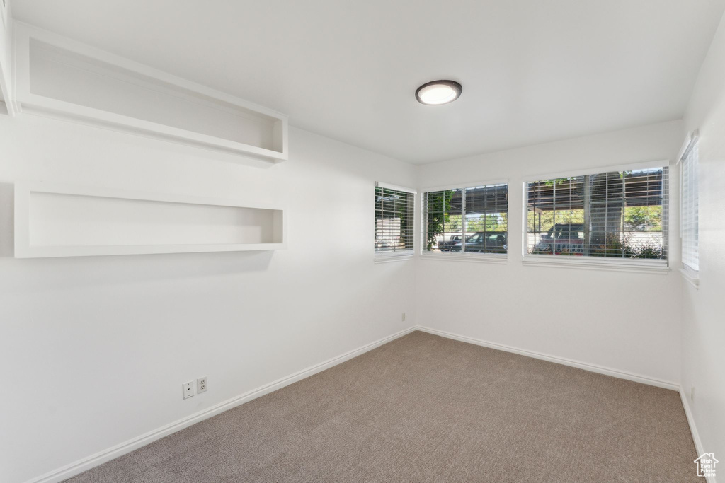 Carpeted empty room with healthy amount of natural light and baseboards