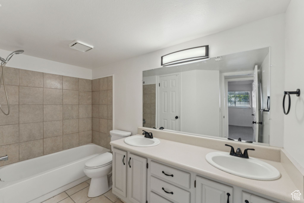 Full bathroom featuring double vanity, toilet, shower / bathtub combination, and tile patterned flooring