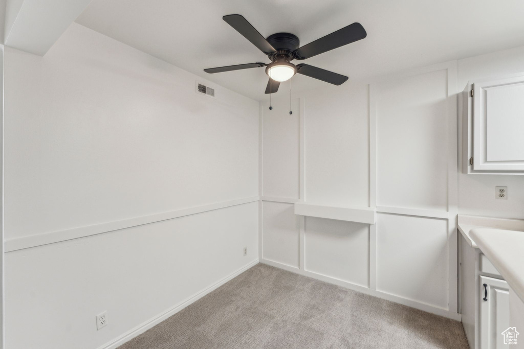 Unfurnished dining area featuring light colored carpet and ceiling fan