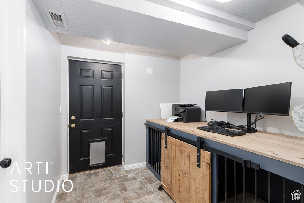 Home office with baseboards and stone finish floors