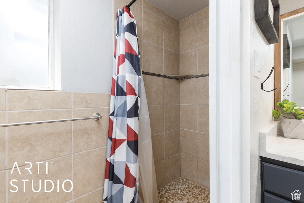 Full bath with a tile shower and vanity