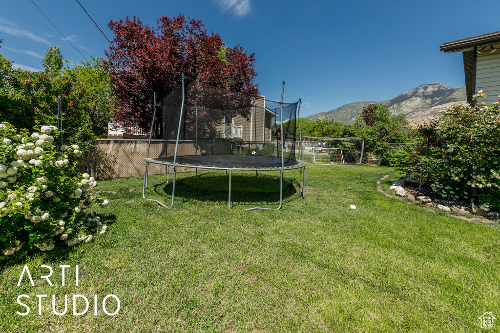 View of yard with a trampoline and a mountain view
