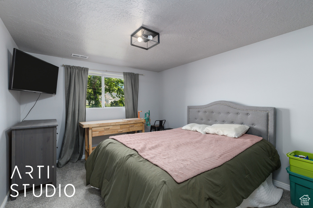Bedroom featuring carpet floors, a textured ceiling, and baseboards
