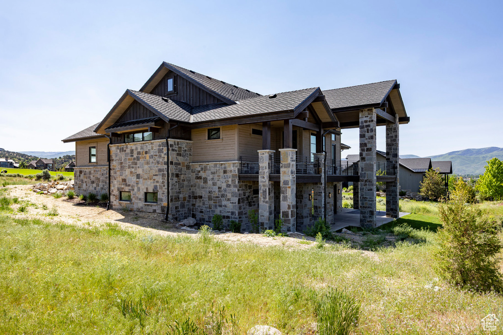 View of side of home with board and batten siding, stone siding, and a mountain view