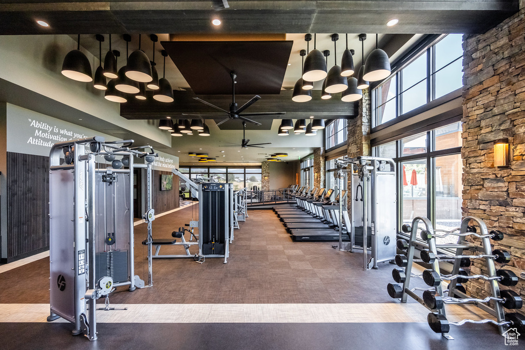 Workout area with a ceiling fan and a high ceiling
