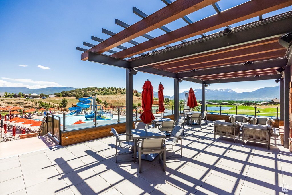 View of patio with a mountain view, outdoor dining space, a pergola, and an outdoor living space