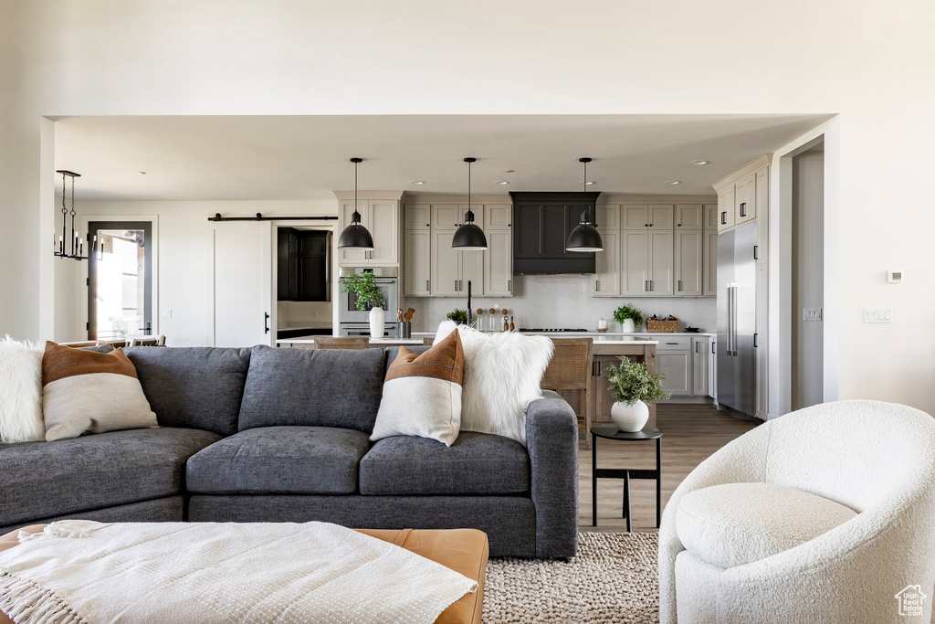 Living area featuring wood finished floors, recessed lighting, and a barn door