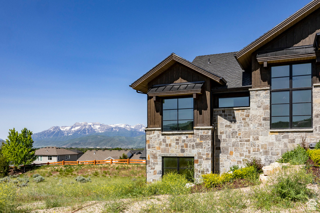 View of property exterior featuring stone siding, board and batten siding, and a mountain view
