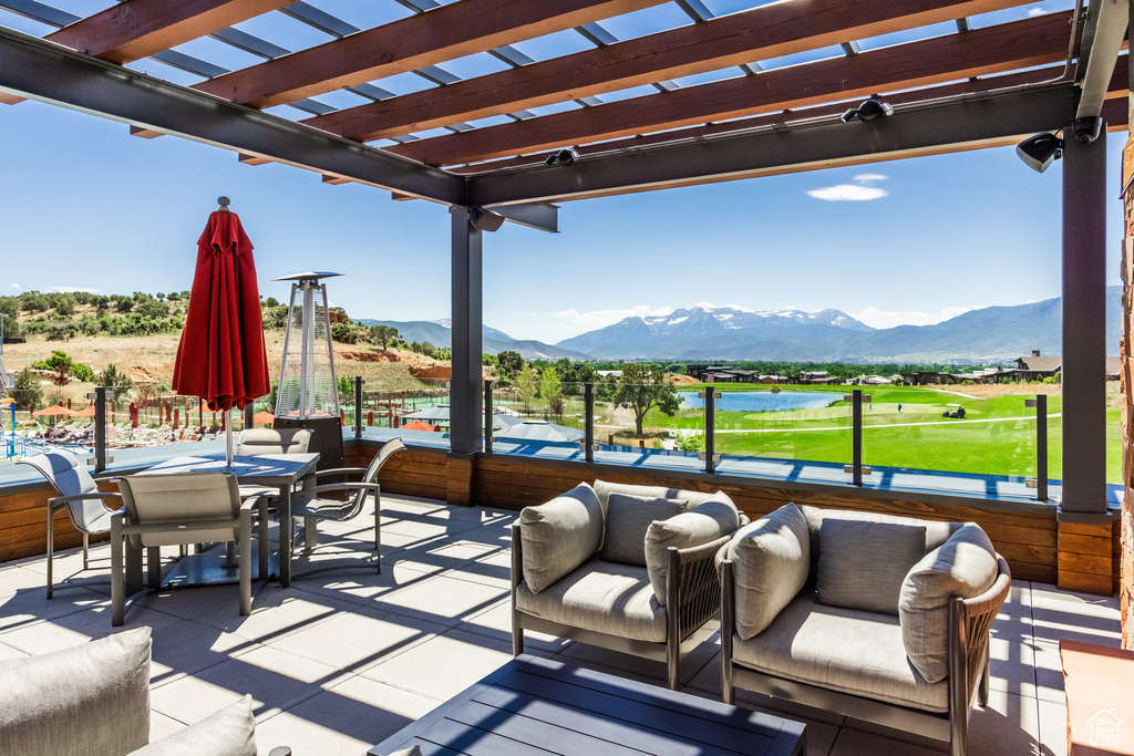 View of patio / terrace featuring a pergola, golf course view, a water and mountain view, and outdoor dining space