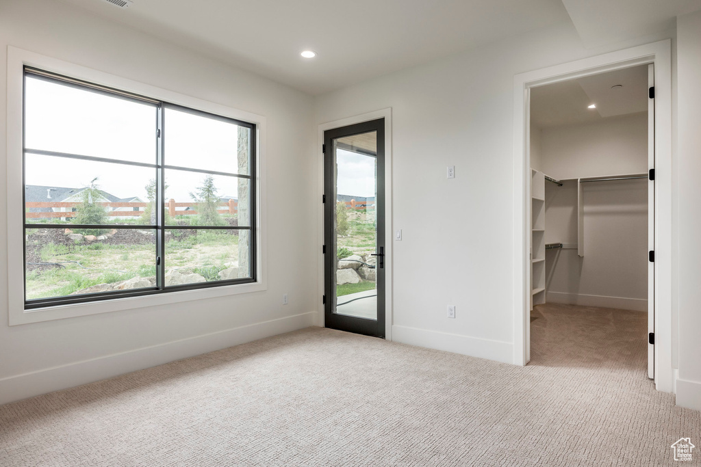 Unfurnished bedroom with carpet floors, multiple windows, baseboards, and recessed lighting