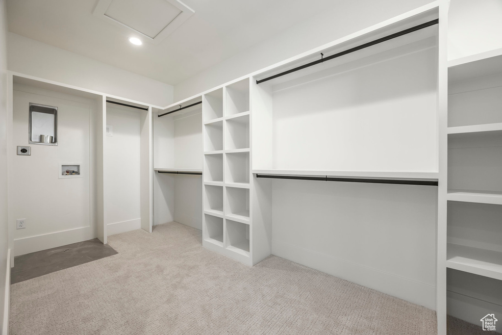 Walk in closet with carpet flooring and attic access