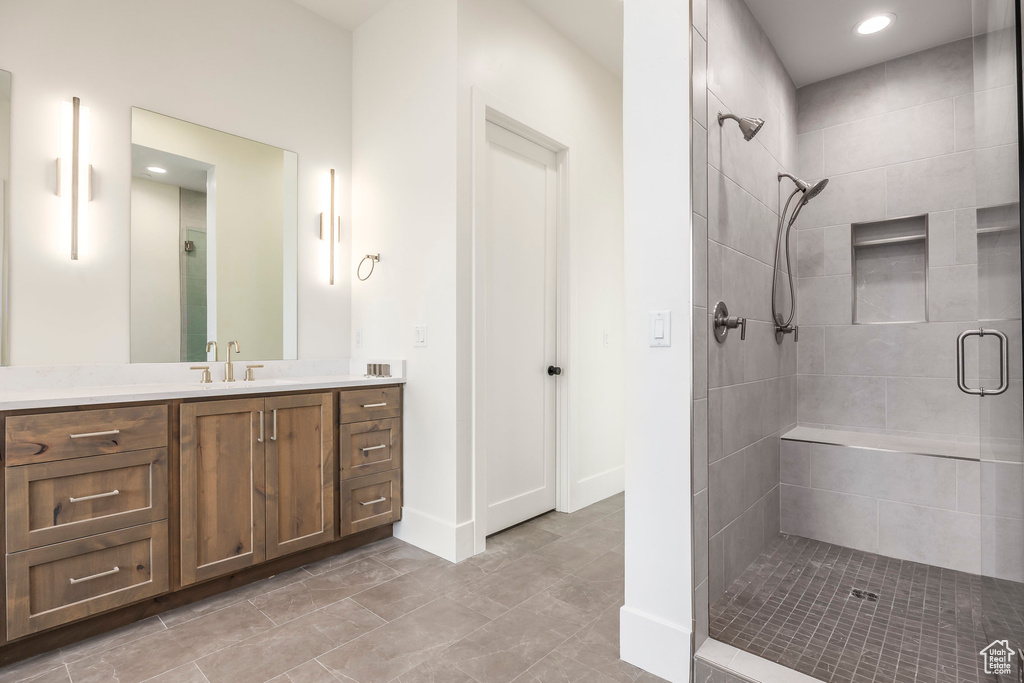 Bathroom with a shower stall, vanity, recessed lighting, and baseboards