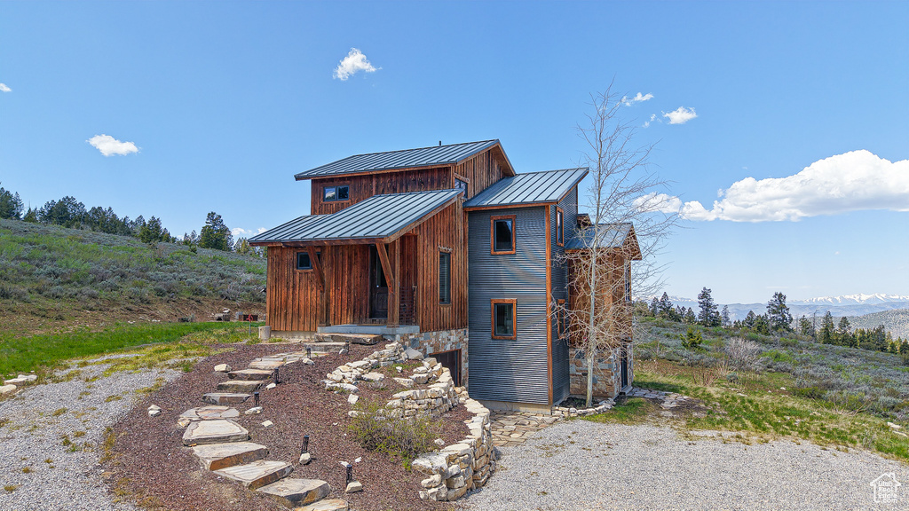 View of front of house with a standing seam roof, metal roof, board and batten siding, and a mountain view