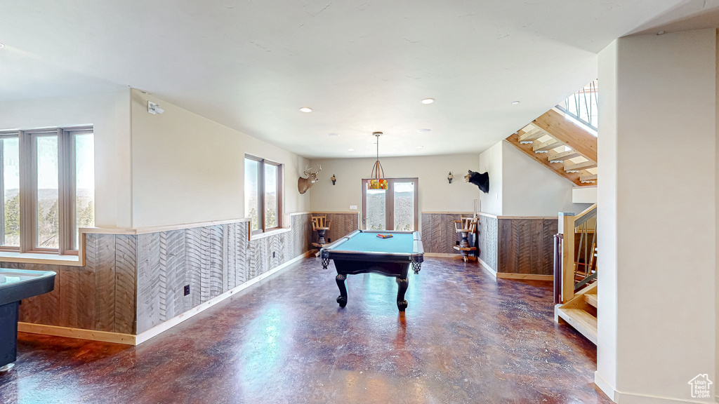 Rec room with a wainscoted wall, pool table, finished concrete floors, baseboards, and recessed lighting