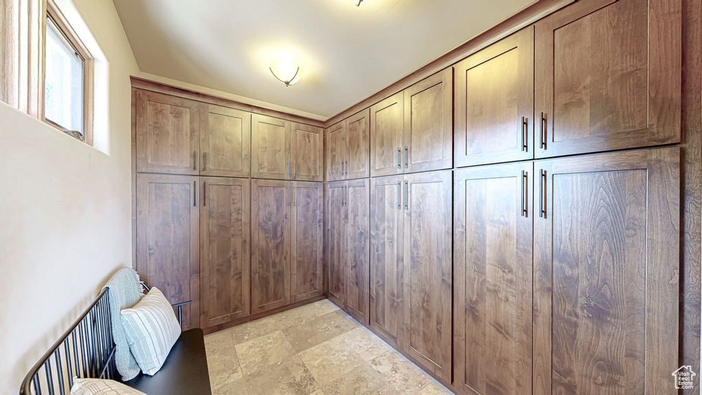 Walk in closet with light stone finish flooring